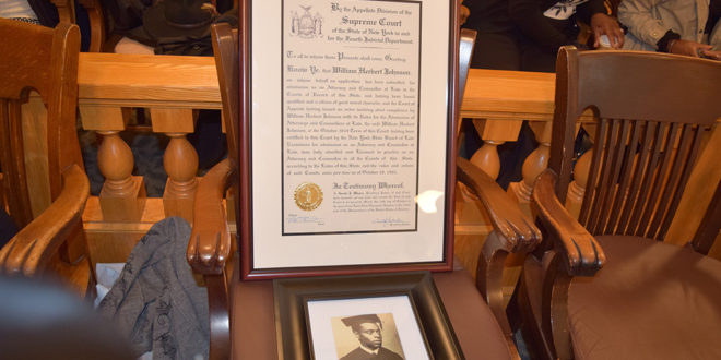 A photo of William Herbert Johnson with a framed certificate admitting him to the New York State Bar Association. | Brenda Muhammad, Staff Photographer